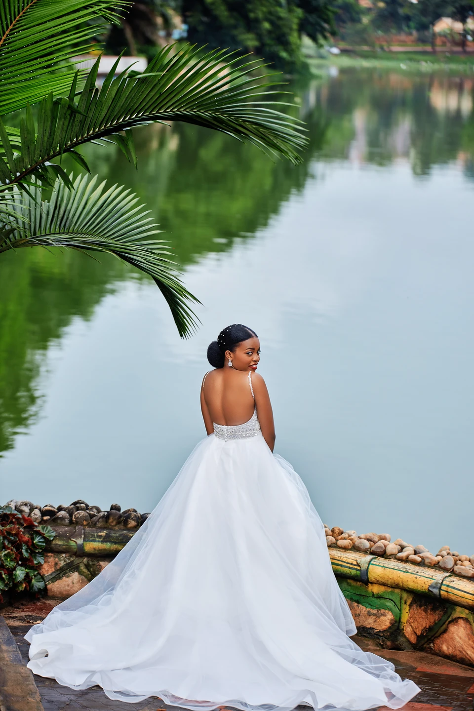 Bride in a flowing wedding dress beside a lake